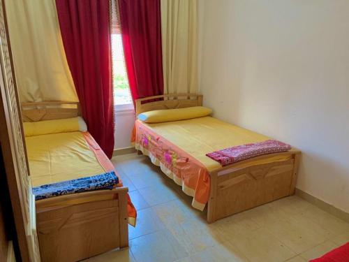 2 łóżka pojedyncze w pokoju z oknem w obiekcie Marina Wadi Degla Resort Families Only w mieście Ajn Suchna