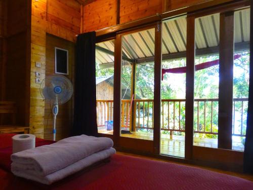 a room with a bed with a fan and windows at Santi Garden Bungalows in Iboih