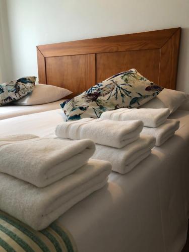 a pile of towels sitting on top of a bed at Airiños do Mar in Areas