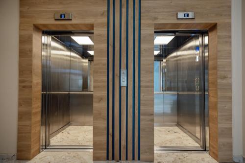 two elevators in a building with glass doors at HOTEL TALIA in Herceg-Novi