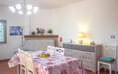 ein Esszimmer mit einem Tisch und einer Obstschale darauf in der Unterkunft Sardinia SeaBreeze Villa IUN R2178 in Castelsardo