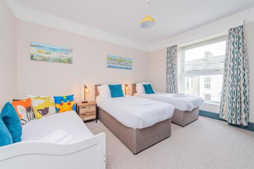 a bedroom with two beds and a window at Snowdon House, 8 bedrooms, sleep 16, close to Blackrock Sand in Porthmadog