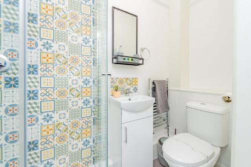 a bathroom with a toilet and a sink and a mirror at Snowdon House, 8 bedrooms, sleep 16, close to Blackrock Sand in Porthmadog