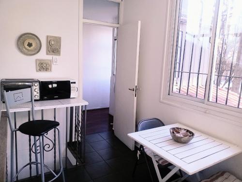 uma pequena cozinha com uma pequena mesa e um frigorífico branco em CASA ARISTIDES em Mendoza