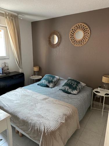 une chambre avec un lit et deux miroirs au mur dans l'établissement Ninon, à Nice