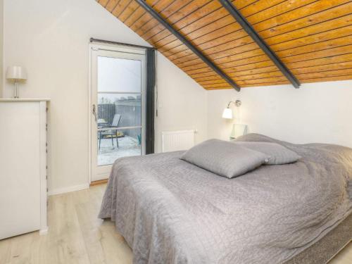 Un dormitorio con una cama y una ventana grande. en Bright Cottage with Hot Tub - By Traum Ferienwohnungen, en Bøtø By