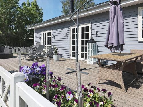a wooden deck with a picnic table and an umbrella at Luxury Spa Retreat in Lolland - By Traum Ferienwohnungen in Nakskov