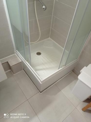 une douche avec une porte vitrée dans une salle de bain dans l'établissement Petite studette à 50m de la plage, à Saint-Jean-de-Monts