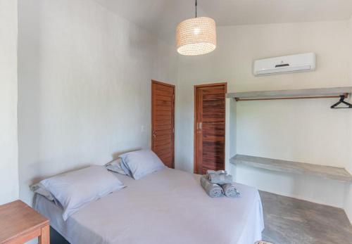 a bedroom with two white beds and a lamp at Vila Viva in Barra Grande