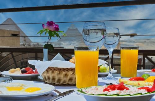 un tavolo con piatti di cibo e bicchieri di succo d'arancia di Pyramids Gem Plaza Hotel & Suites a Il Cairo