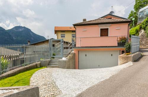 a house with two garage doors and a fence at Casa Maria in Nesso