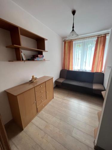 a living room with a couch and a bed in a room at Apartament Na Piątkę in Sopot
