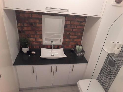 a bathroom with a white sink and a mirror at 36 HydePark Apartments in Cape Town