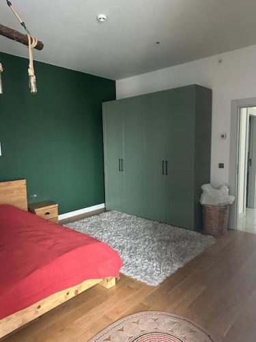 a bedroom with a red bed and green walls at SİNPAŞ QUEEN BOMONTİ 320 in Istanbul