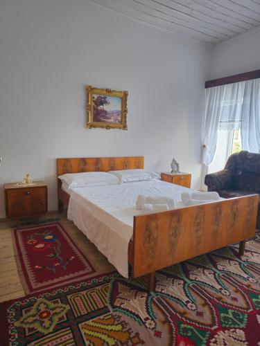 - une chambre avec un grand lit dans une pièce dotée d'un tapis dans l'établissement Traditional House Shapllo, à Gjirokastër