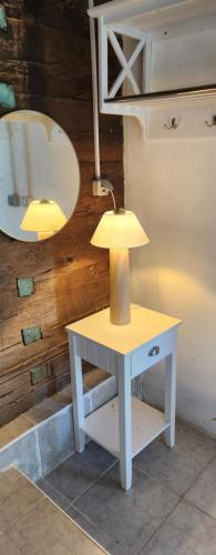eine Lampe auf einem Tisch neben einem Spiegel in der Unterkunft Old Mill 
