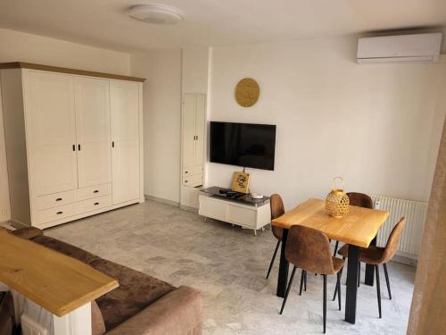 un salon avec une table et une télévision dans l'établissement Studio entre plages et Monaco climatisé parking, à Roquebrune-Cap-Martin