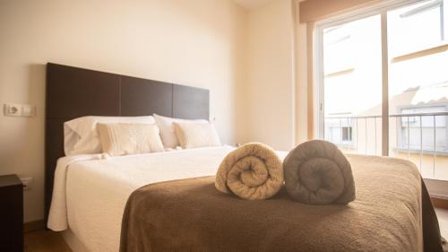 1 dormitorio con 1 cama con toallas en Apartamento nuevo al lado de la playa en A Guarda, en A Guarda