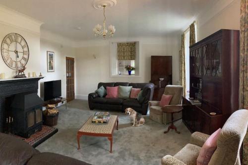 a living room with a dog sitting in front of a fireplace at Polharrow in Dalry