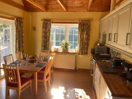 a kitchen with a wooden table and a dining room at Polharrow in Dalry