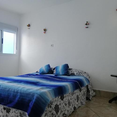 - une chambre avec un lit doté de draps bleus et une fenêtre dans l'établissement Casa Mar, à Chefchaouen