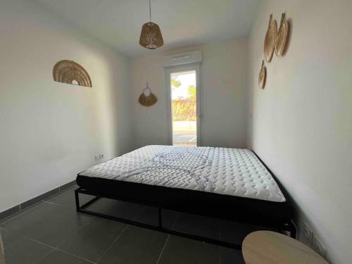 a bedroom with a bed in the corner of a room at App Le Golf T3 terrasse wifi pkg in Béziers