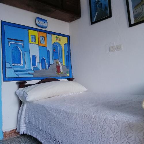 - une chambre avec un lit orné d'une peinture murale dans l'établissement Casa Mar, à Chefchaouen