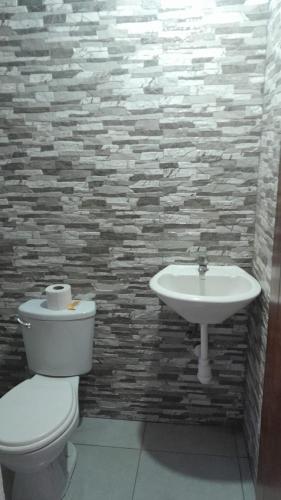 a bathroom with a toilet and a sink at Tropical Lodge in Cabanaconde