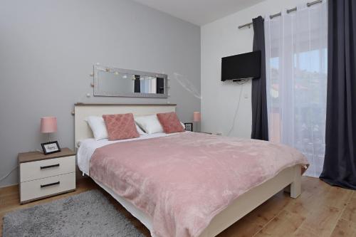 Un dormitorio con una cama grande y un televisor. en Apartment Pag 6412b, en Pag