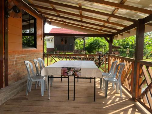 una mesa blanca y sillas en una terraza de madera en Family Room HAMSHA VILLAGE, 