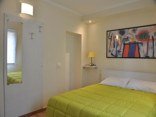 una camera con un letto verde e un dipinto sul muro di San Guglielmo Apartments a Ferrara