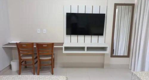 a living room with a television and a table and chairs at SPAZZIO Andrian & Silva - INCLUSOS INGRESSOS DO PARQUE in Caldas Novas