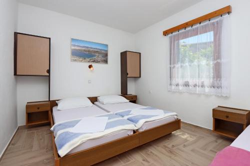 1 Schlafzimmer mit 2 Betten und einem Fenster in der Unterkunft Apartments with a parking space Potocnica, Pag - 6338 in Borovići