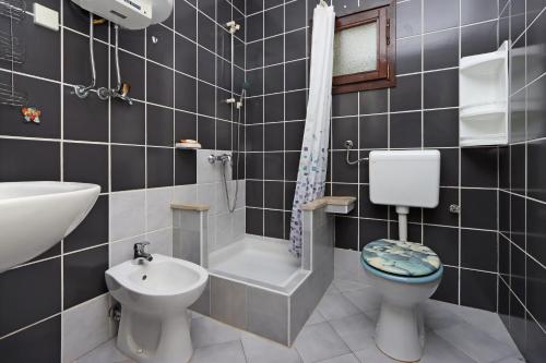 a bathroom with a toilet and a sink and a bath tub at Apartments with parking space Potocnica, Pag - 6338 in Borovići