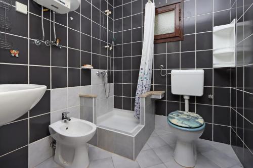 a bathroom with a toilet and a sink and a bath tub at Apartments with a parking space Potocnica, Pag - 6338 in Borovići