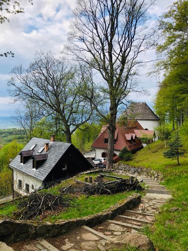 uma pequena casa numa colina com árvores e casas em dom pod jaworami em Sosnówka