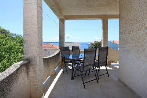 a patio with a table and chairs on a balcony at Apartments by the sea Mandre, Pag - 3084 in Kolan