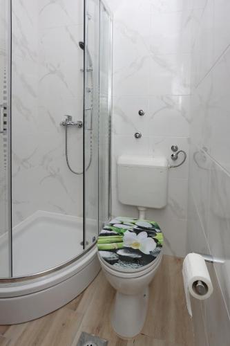 a white bathroom with a toilet and a shower at Apartments by the sea Mandre, Pag - 3084 in Kolan