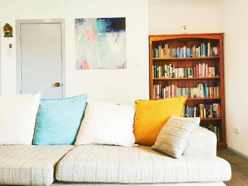 a living room with a couch with colorful pillows at 4 bdm house+sleep-out in Pukete.Close to The Base in Hamilton