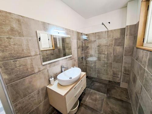 ein Badezimmer mit Waschbecken und Spiegel in der Unterkunft Apartments Ivanka in Supetar