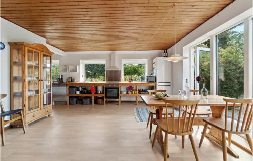 a kitchen and dining room with a wooden ceiling at Nice Apartment In Aakirkeby With Wifi in Åkirkeby