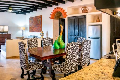 a kitchen with a table and chairs and a refrigerator at Los Cabos Golf Resort, Trademark Collection by Wyndham in Cabo San Lucas