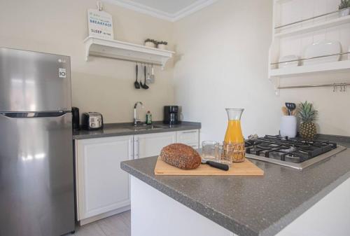 a kitchen with a stainless steel refrigerator and a bread on a cutting board at Villa Oasis in Palm-Eagle Beach