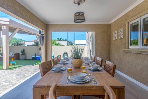 a dining room with a wooden table and chairs at Villa Oasis in Palm-Eagle Beach