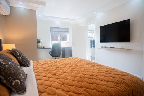 a bedroom with a large bed and a flat screen tv at Villa Oasis in Palm-Eagle Beach