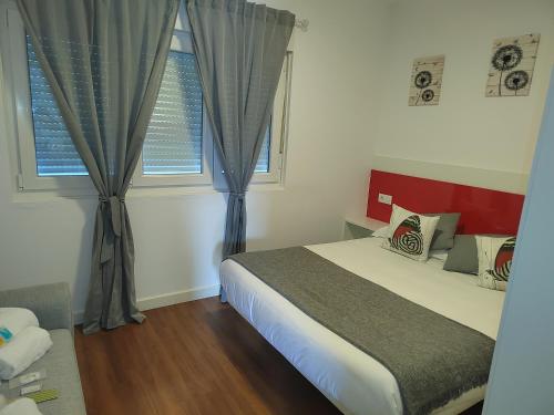 - une chambre avec un lit et 2 fenêtres dans l'établissement Apartamentos en Leis Muxia, à Leis