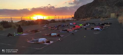 a group of people laying in a parking lot at sunset at Los Abrigos 2 apartments Guest House Ocean relax, wifi, playas in Los Abrigos