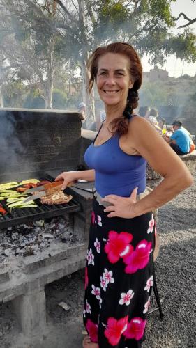a woman standing in front of a grill at Los Abrigos 2 apartments Guest House Ocean relax, wifi, playas in Los Abrigos