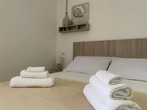een slaapkamer met een bed met handdoeken erop bij Go Island in Praia a Mare