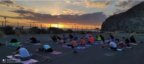 a group of people doing yoga on the beach at sunset at Los Abrigos 2 apartments Guest House Ocean relax, wifi, playas in Los Abrigos